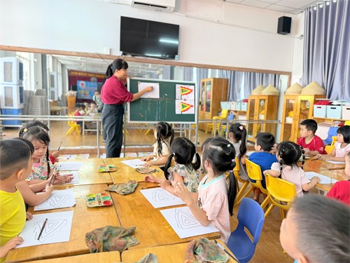 Các bé lớp mầm 2 học vẽ lá cờ ngũ sắc
