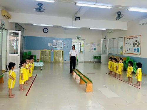 Các bé lớp bambi 2 cùng nhau học tiết thể chất 
 đi trên ghế đầu đội túi cát 