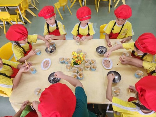 Các bé pooh 1 thực hiện kỹ năng làm bánh que nhúng sô cô la, kẹo cốm