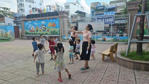 Trường MN Sơn Ca: Các bé lớp Chồi hào hứng chơi thả máy bay giấy dưới sân trường.