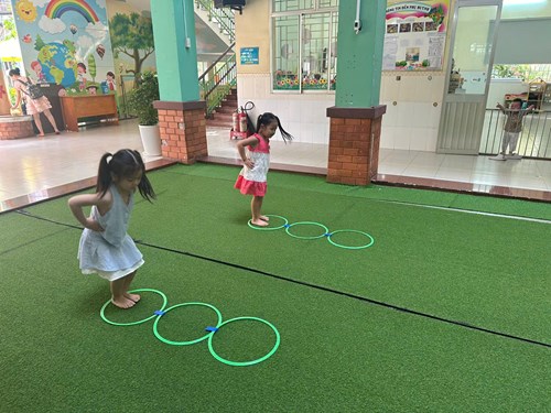 Các bạn Lớp Mầm 1 thực hiện bài tập tổng hợp Bật qua vòng - chui qua cổng
