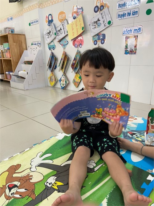 Bé đọc sách góc thư viện - lớp mầm 1