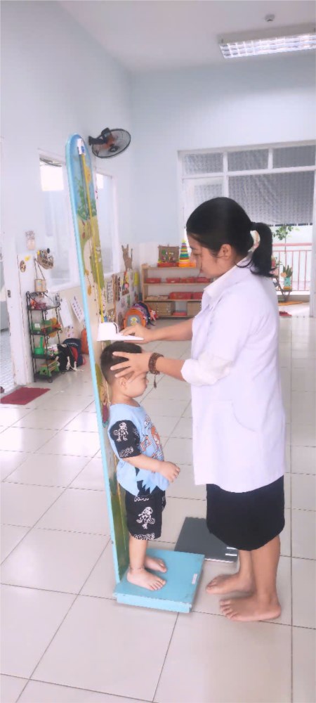 Nhân viên y tế  trường Mầm non Họa Mi 2 tổ chức cân đo trẻ vào tháng 12 năm 2024