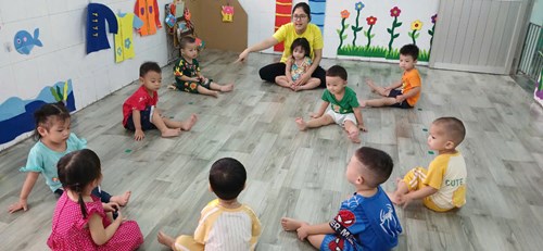 Các bé chơi lăn bóng cùng cô