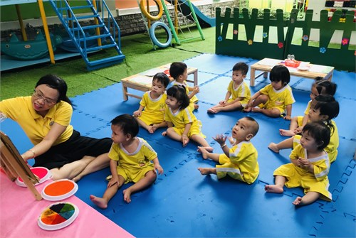 Các bé lớp 13-24 tháng với hoạt động học  In màu bông hoa 