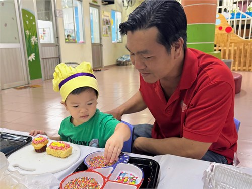 Phụ huynh cùng các bé lớp 13-24 tháng thực hiện kỹ năng làm bánh kem trong ngày hội mùa đông.