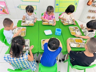 Các bé lớp Chồi 2 ăn cơm trưa bằng khay