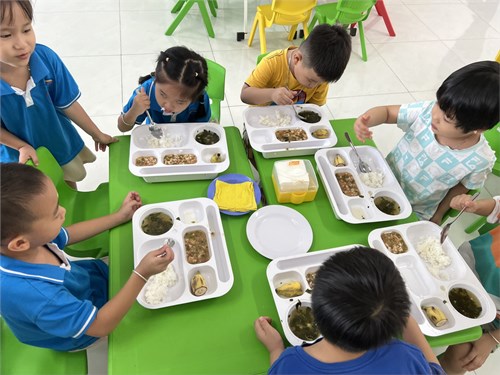 Lớp Chồi 1 cho trẻ ăn cơm bằng khay