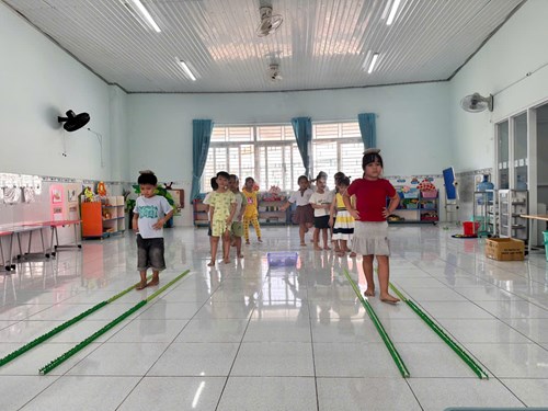 Bé học  Đi trong đường hẹp đầu đội túi cát  - lớp Vành khuyên 4
