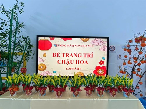 Bé trang trí chậu hoa ngày tết