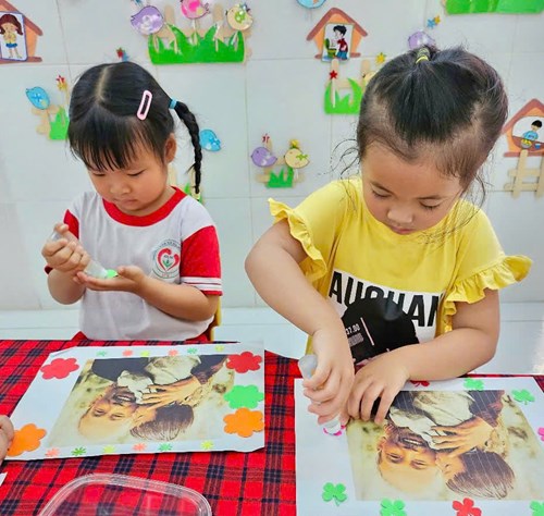 Bé trang trí khung ảnh Bác từ nhiều nguyên liệu