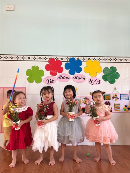 Các bé Nhóm 25-36 tháng (2) cắm hoa tặng mẹ mừng ngày 8/3 .