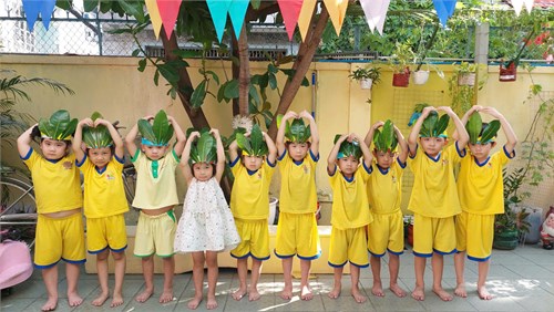 Bé tạo hình mũ từ lá cây