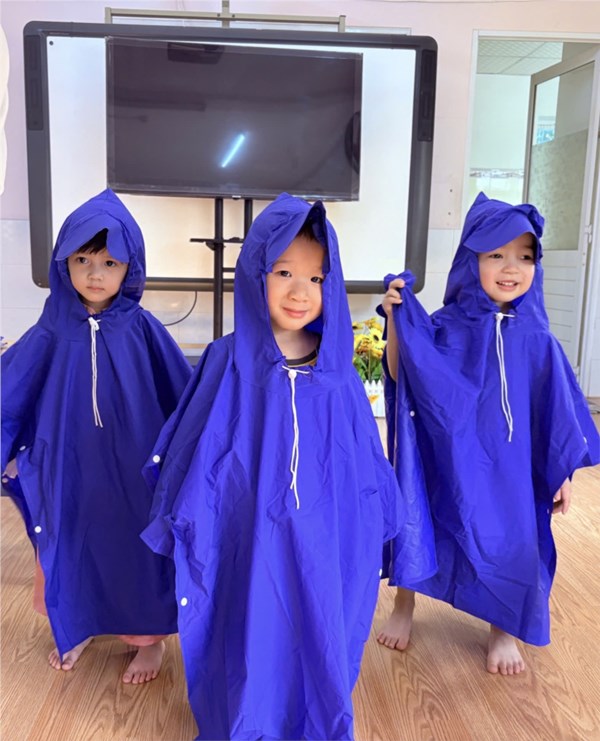 Hướng dẫn trẻ mặc áo mưa đúng cách.