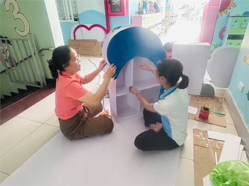 Các cô giáo chuẩn bị các kệ sách, bàn đọc sách phòng Thư viện trường MN Mỹ Hòa