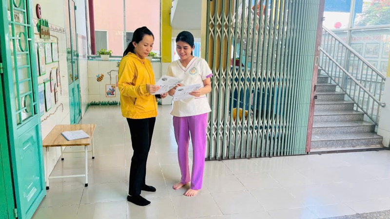 Giáo viên thực hiện công tác tuyên truyền bệnh tay-chân-miệng đến cha mẹ trẻ.