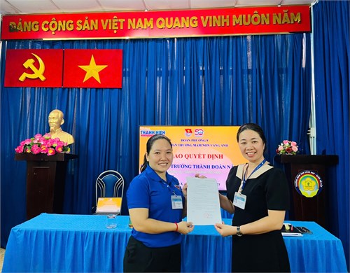 Đồng chí Vũ Thị Kim Thoa_Bí thư Chi bộ, Hiệu trưởng Trường MN Vàng Anh trao quyết định trưởng thành Đoàn cho đồng chí Nguyễn Hoàng Mỹ Linh.